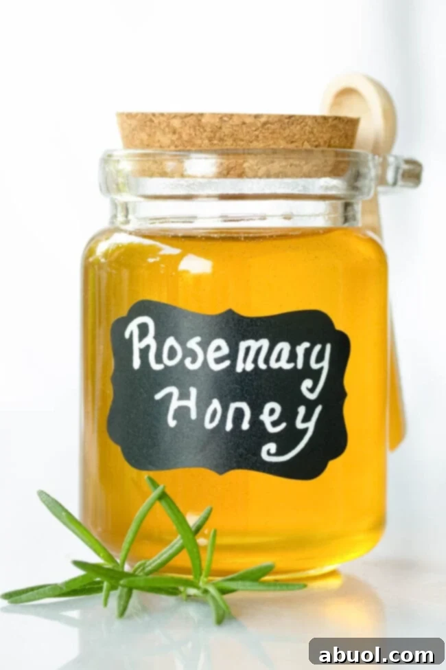 A small glass jar filled with golden rosemary-infused honey, clearly labeled as 'rosemary honey' and ready to be enjoyed or gifted.