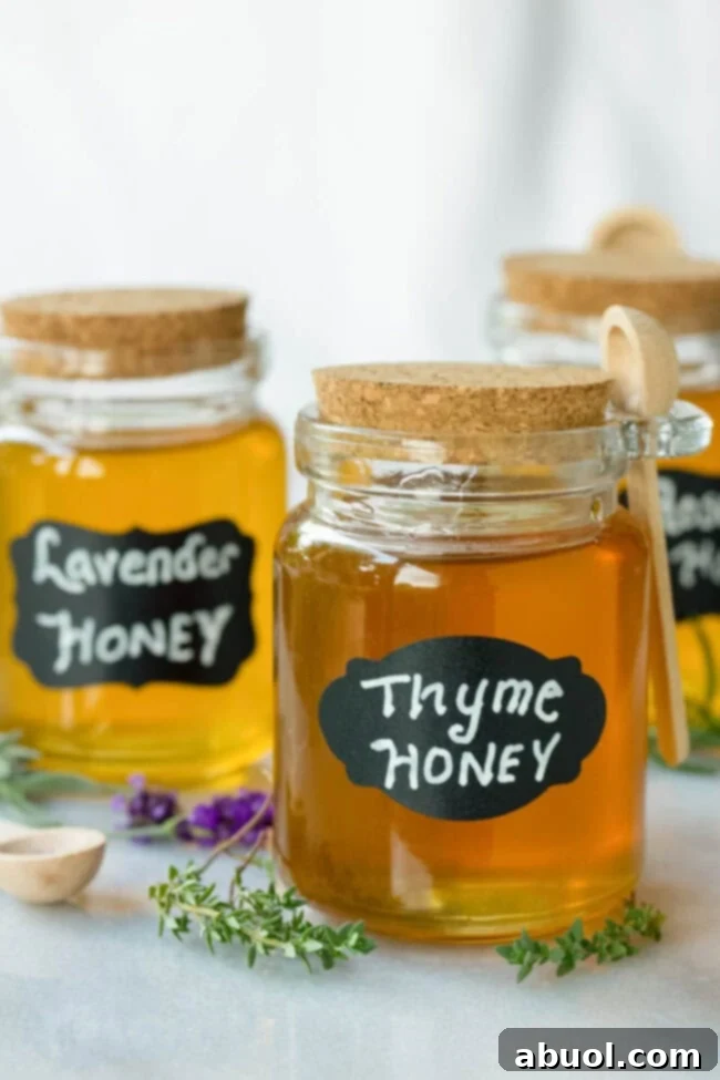 An inviting display of three small glass jars, each containing a different herb-infused honey, labeled 'thyme honey,' 'lavender honey,' and 'rosemary honey,' showcasing the variety possible.