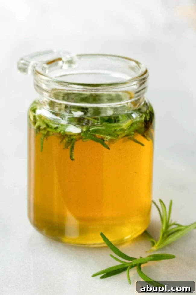 A charming small glass jar is prominently displayed, generously filled with golden honey, featuring a vibrant sprig of fresh rosemary gently infusing within.