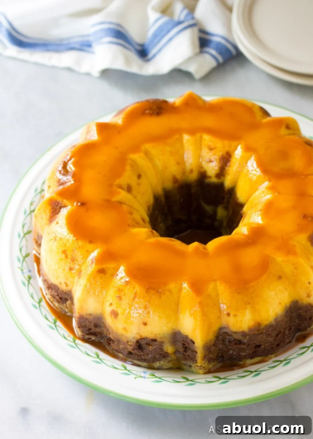 A freshly baked Mexican Chocoflan Impossible Cake, inverted onto a serving platter, showcasing the beautiful caramel topping and the distinct layers ready to be sliced.