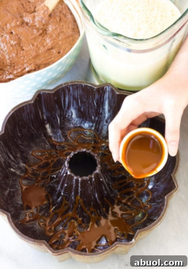 Drizzling rich caramel sauce into the bottom of a greased bundt pan, preparing for the Chocoflan layers.