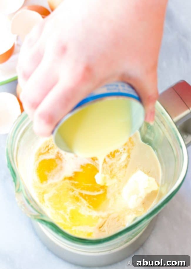 Gently pouring the flan mixture over the chocolate cake batter in the bundt pan, preparing for baking.