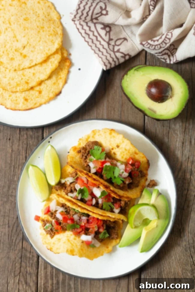 A vibrant overhead shot of three fully loaded tacos, demonstrating the sturdy nature of the low-carb cauliflower tortillas. 
