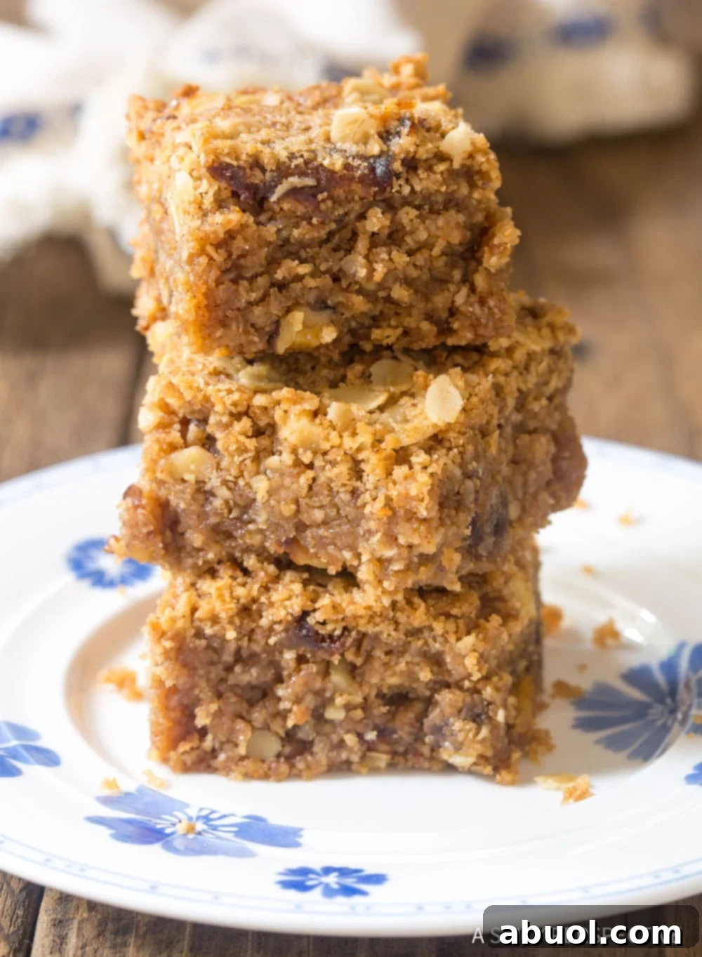 Stack of soft, sweet, golden-brown oat breakfast bars, highlighting their chewy texture and wholesome ingredients.