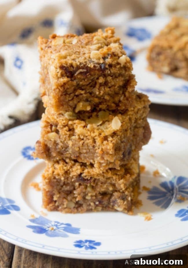 Stacked oat bars on a white plate, showcasing their perfect thickness and golden-brown tops.