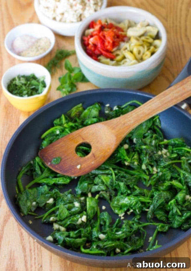 Sauteed spinach in a frying pan, wilted and aromatic.