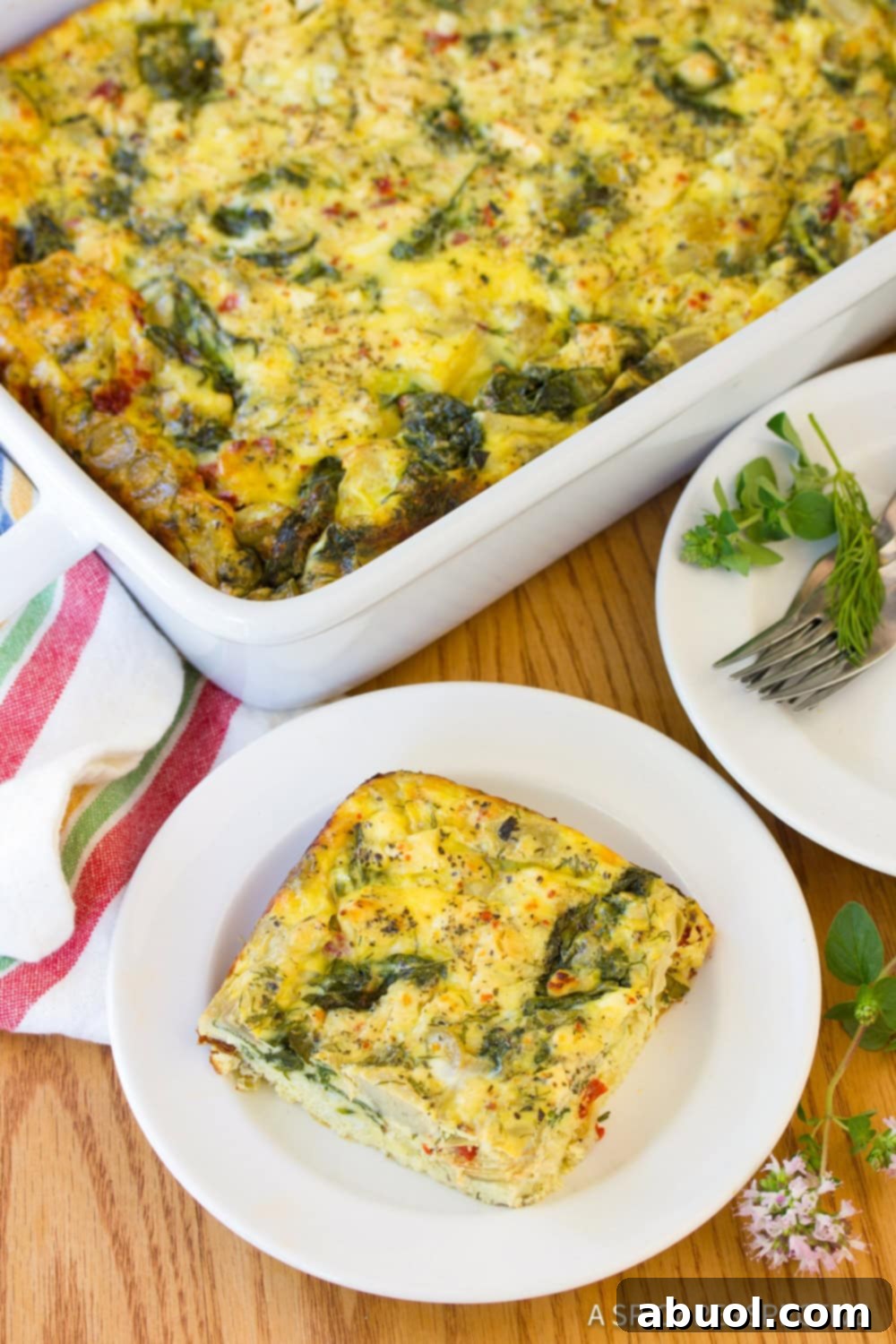 A beautifully presented slice of Greek omelette casserole on a white plate, ready to be enjoyed.