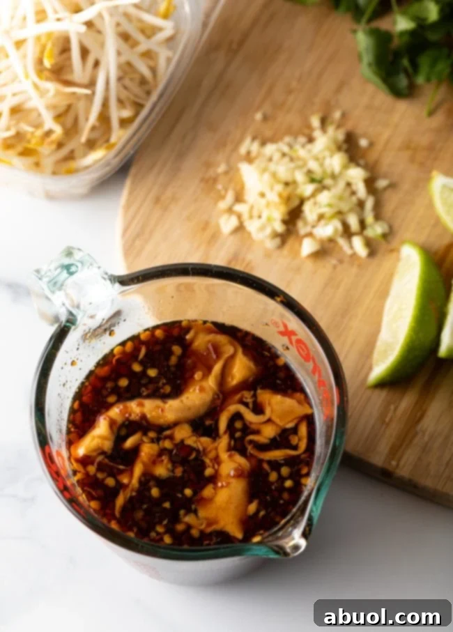 Top-down view of a glass measuring cup filled with perfectly blended Pad Thai sauce ingredients, showcasing the rich color and smooth consistency before it's added to the stir-fry.