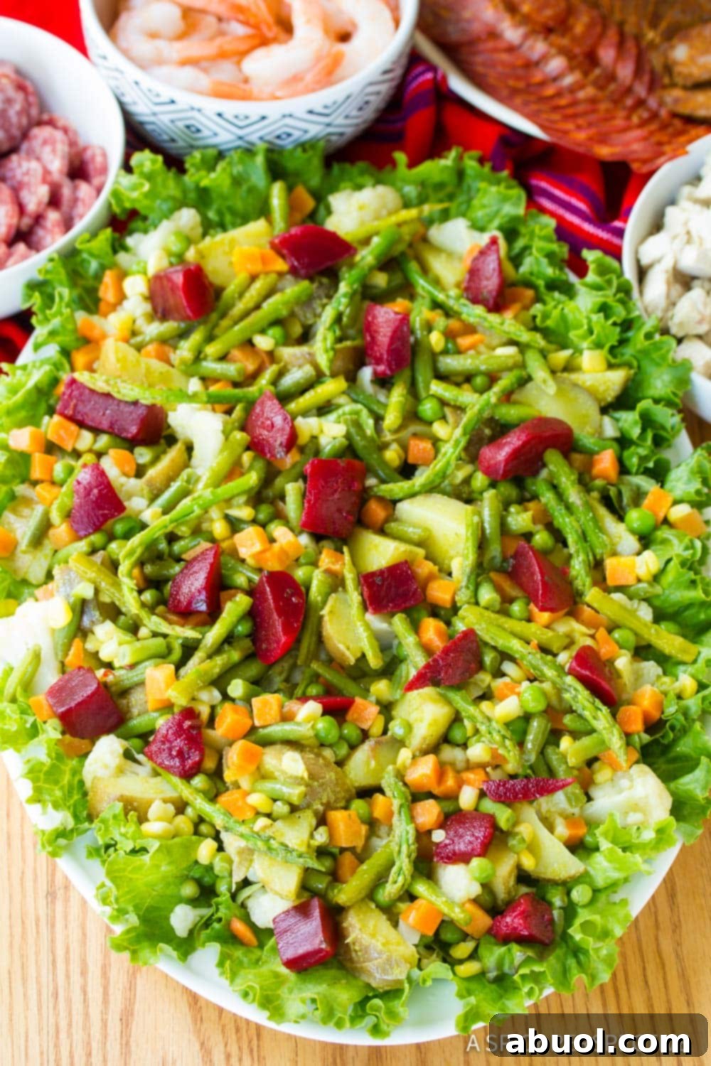 Fiambre salad on a large serving platter with other ingredients in the background. 