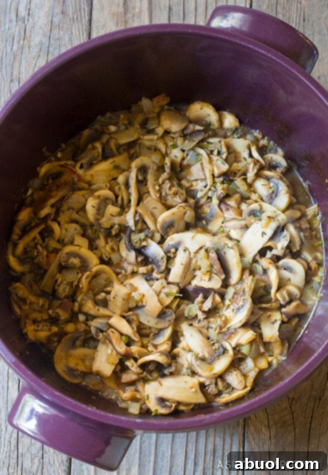 Sautéed mushrooms, sizzling in a pan, a key step for flavorful soup.