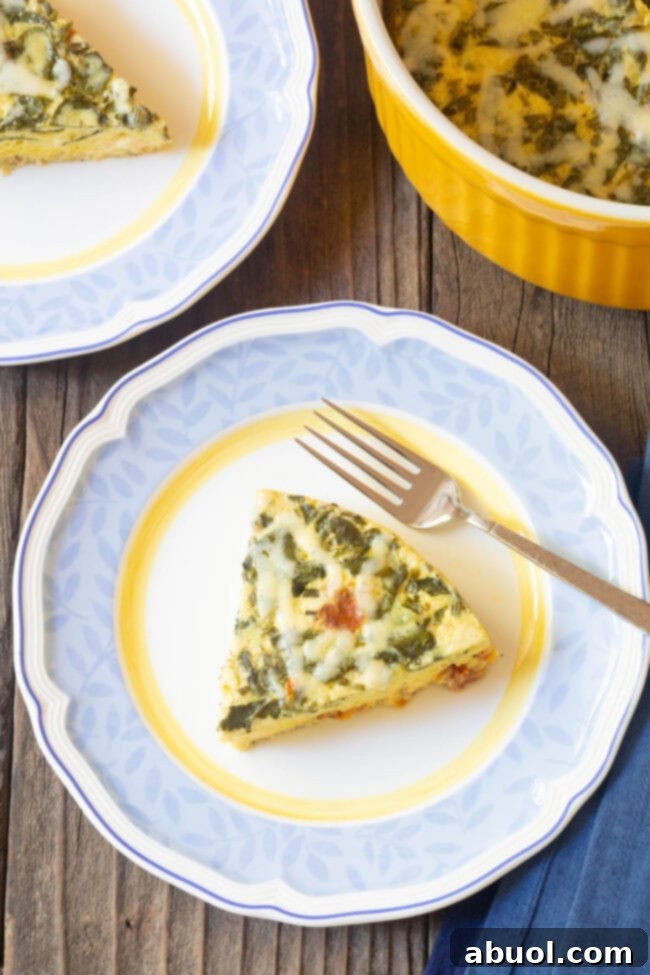 A perfectly cooked slice of Instant Pot Keto Crustless Quiche artfully placed on a simple white plate, showcasing its soft, airy texture.