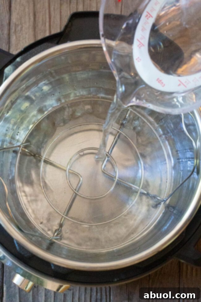 A view inside an Instant Pot with water at the bottom, and a trivet in place, preparing to cook the quiche.