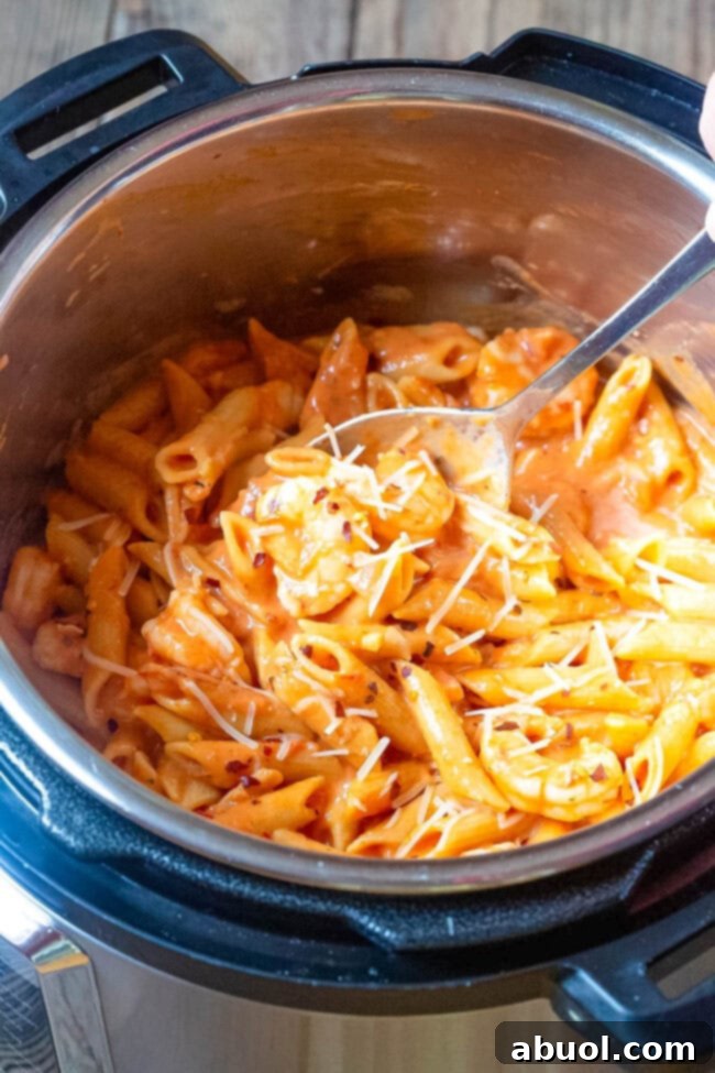 Shrimp pasta with vodka sauce in an instant pot with a spoon in the pot.
