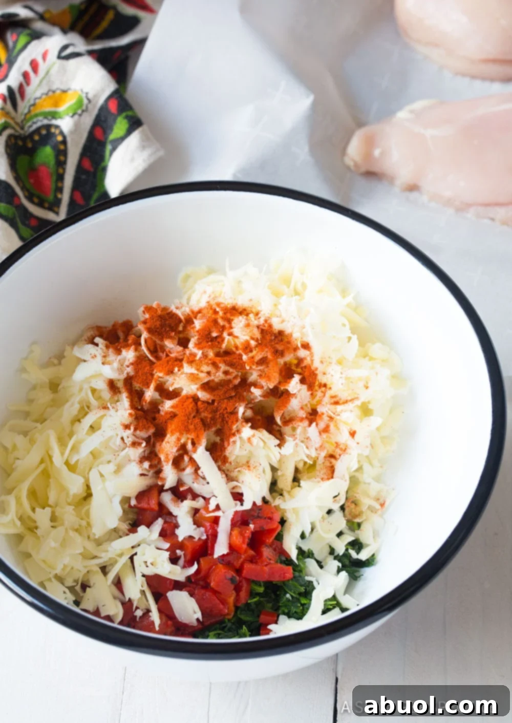 Cheese, spinach and spices in a mixing bowl. 