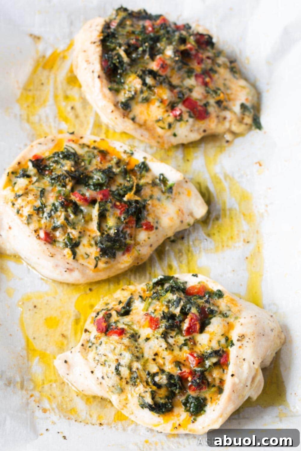 Stuffed chicken breasts on a baking sheet after being baked. 