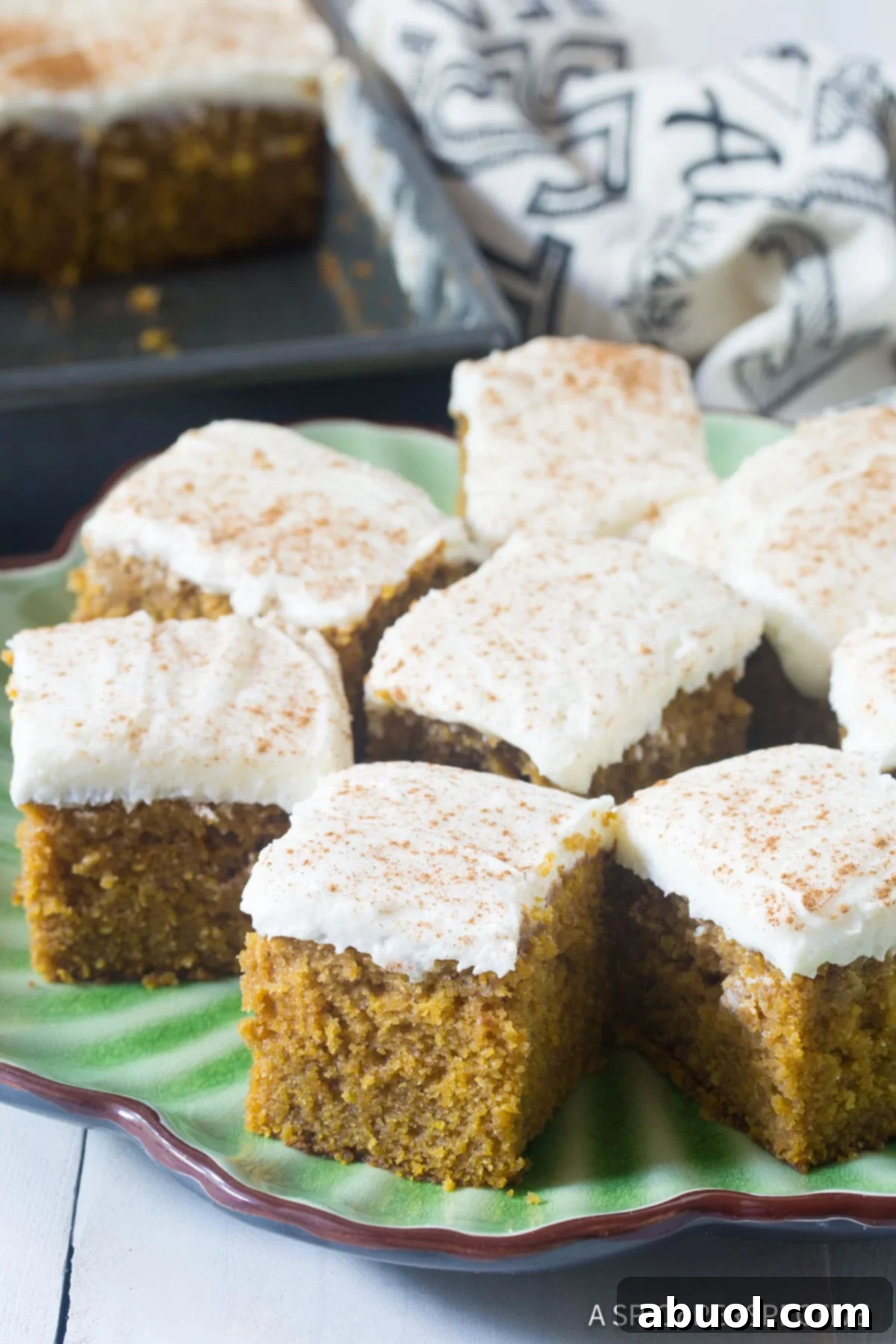 Golden Harvest Pumpkin Sheet Cake 10 Easy Pumpkin Cake with Buttermilk Frosting cut pieces on platter