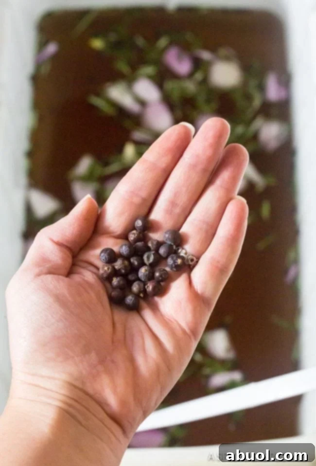 A hand scattering peppercorns over a large cooler filled with turkey brine, illustrating the brining process.