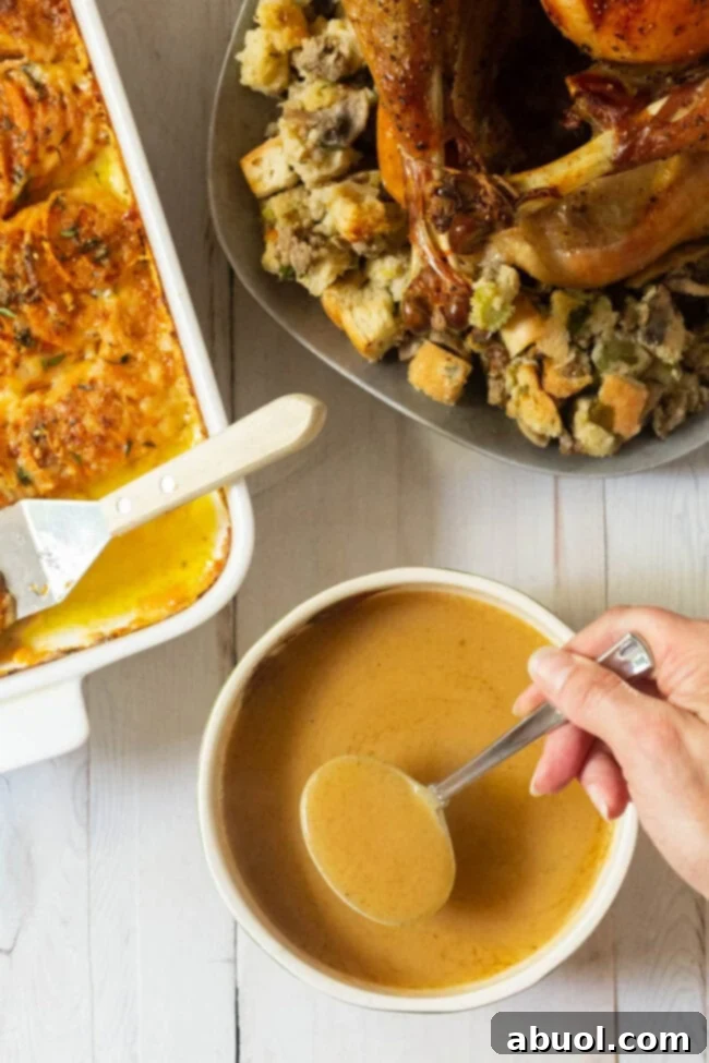 The Ultimate Turkey Gravy 3 Homemade Turkey Gravy Recipe served alongside classic Thanksgiving sides like mashed potatoes and stuffing.