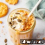 Creamy Pumpkin Shake in a glass with a striped straw in it.