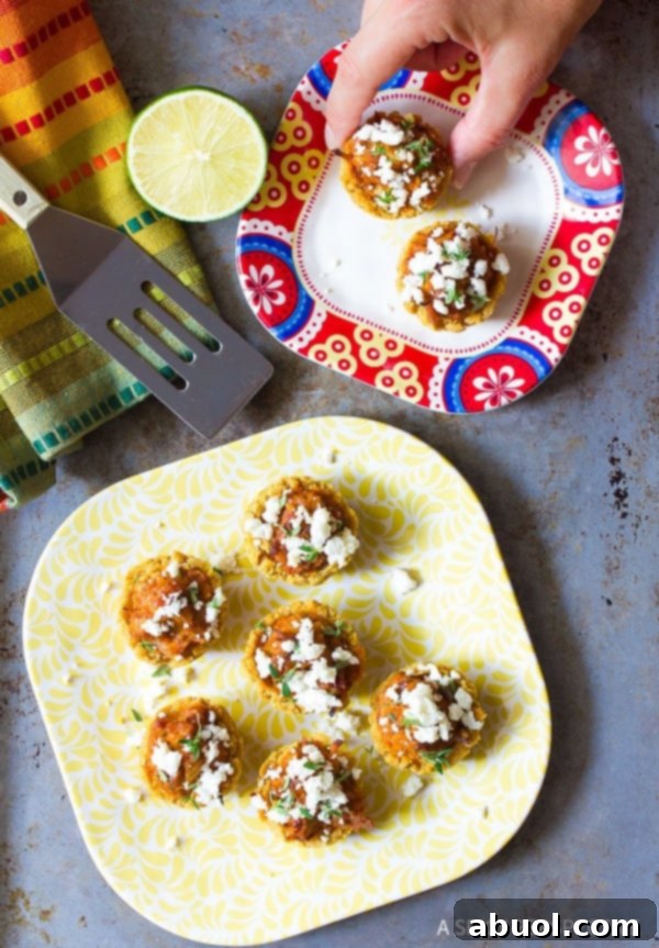 Several Mini Tamales on a platter with crumbled cheese and fresh herbs as garnish.