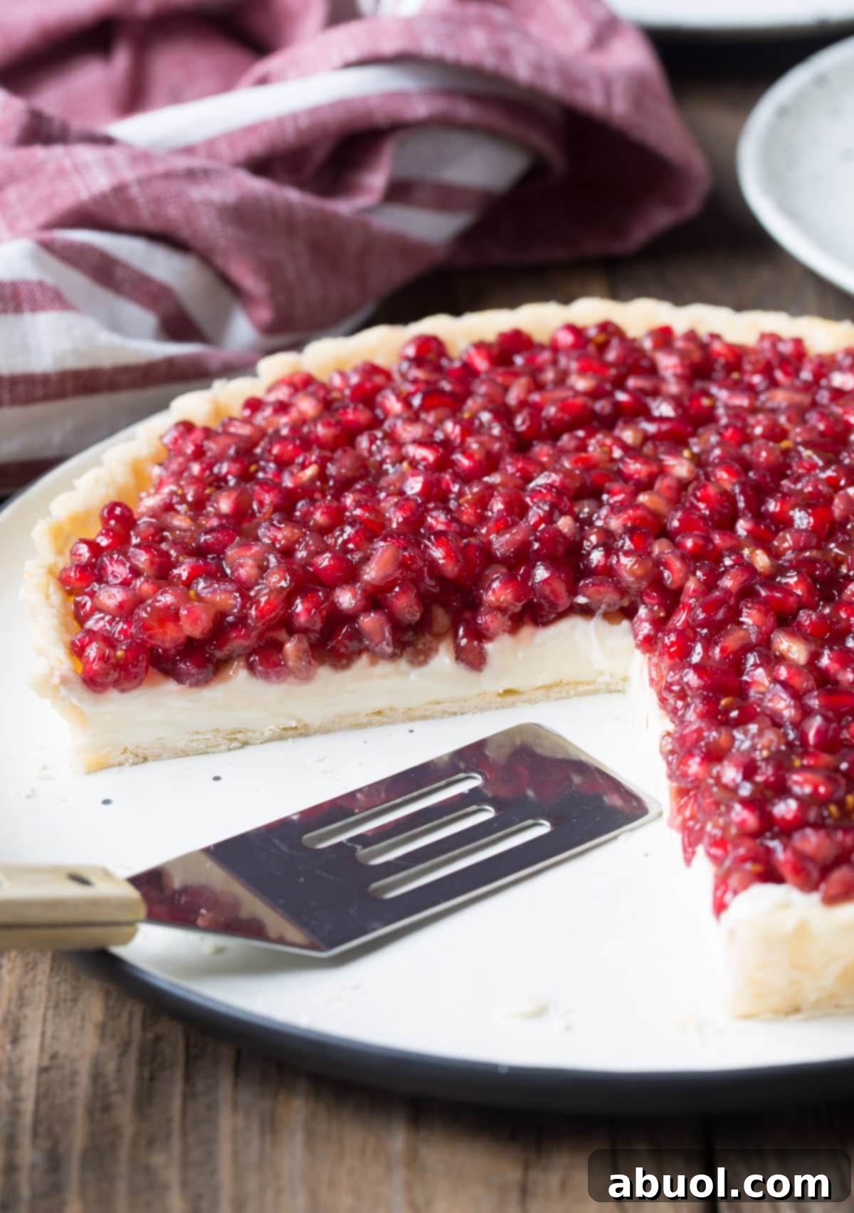 6-Ingredient Pomegranate Tart Recipe with cream cheese - pieces cut out of whole tart