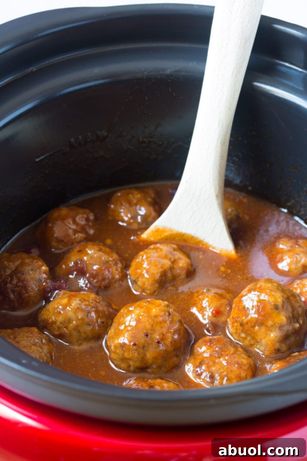 Cooking up the crock pot cocktail meatballs while simmering in the sauce