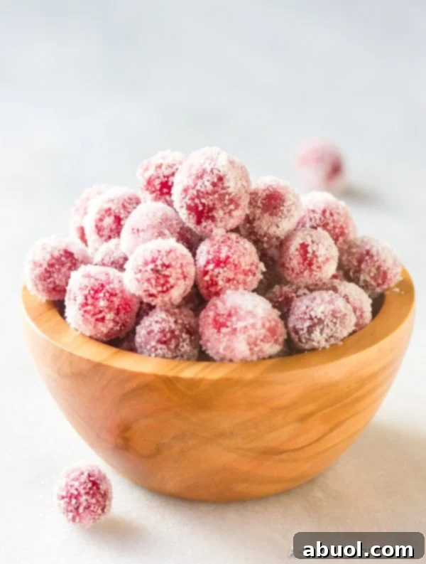 Beautifully arranged Vanilla Orange Candied Cranberries, ready for serving or gifting, with a rustic holiday backdrop.