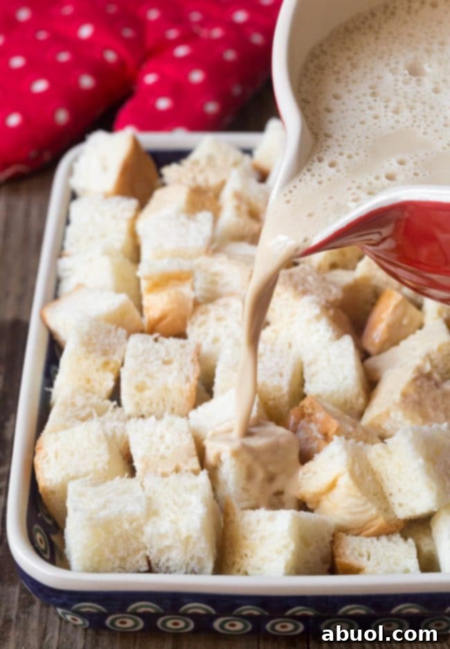 Pouring custard over bread cubes.