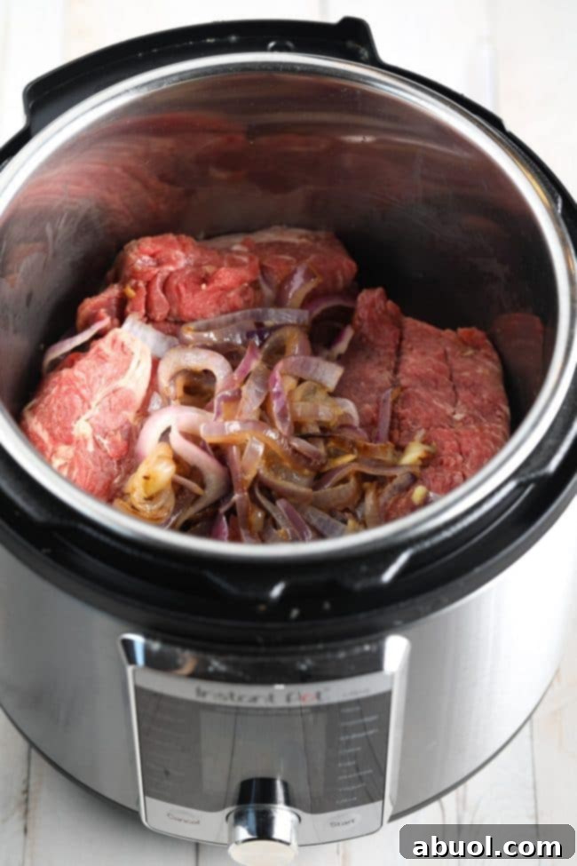 Meat and onions in the pressure cooker before being cooked. 