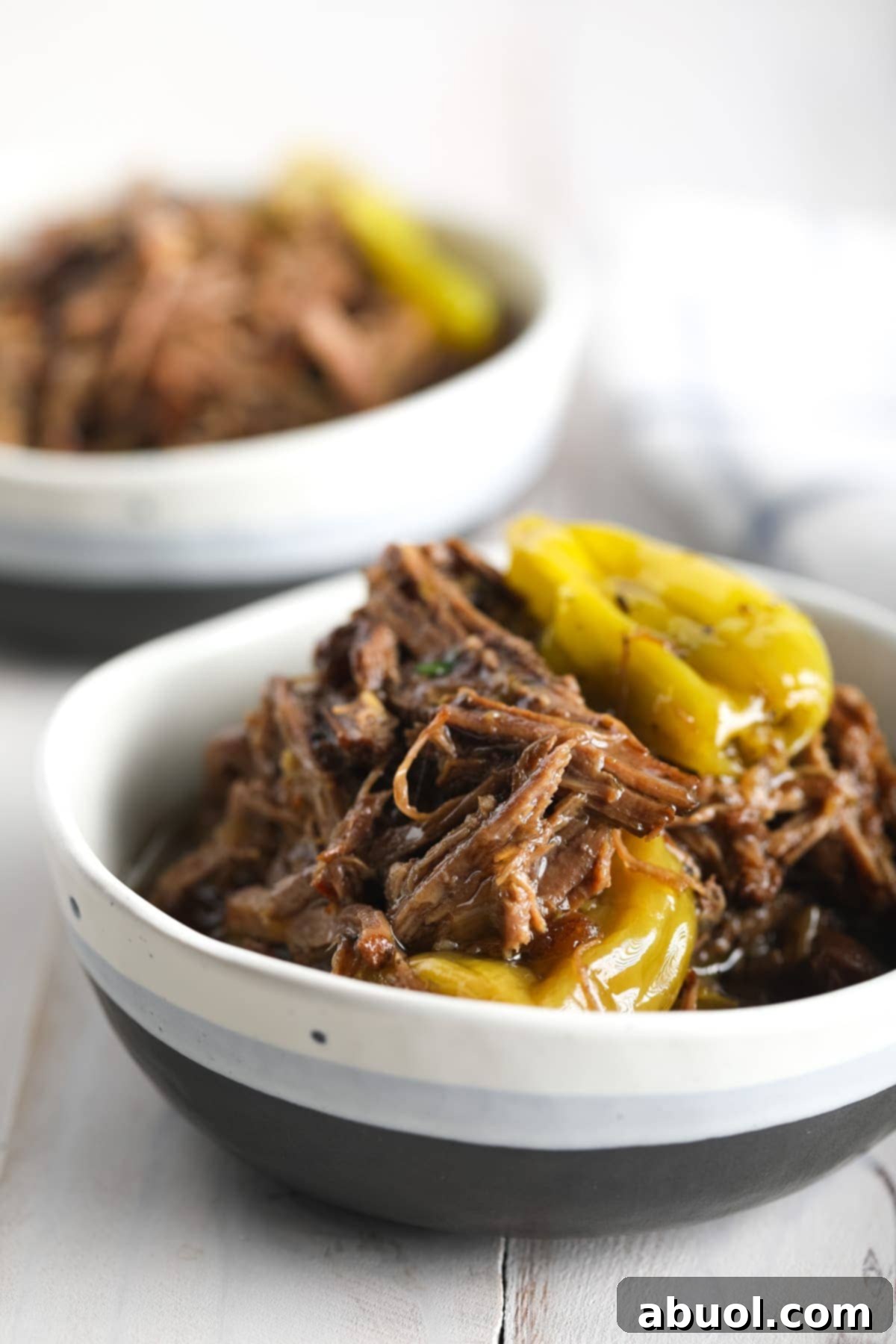 Italian-style shredded beef in a bowl with pepperoncinis. 