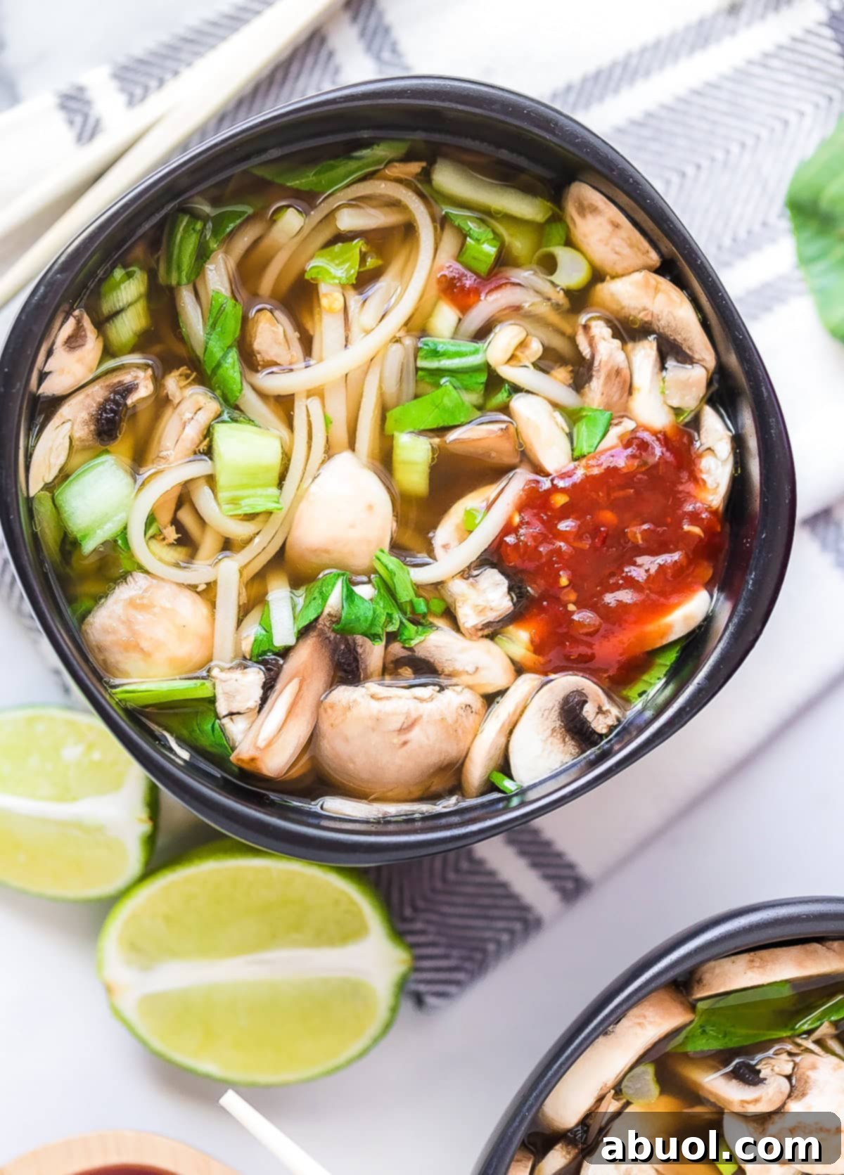 A beautifully presented bowl of Chinese Chicken Hot Pot, viewed from above, with a hint of spicy hot sauce drizzled on top, ready to be enjoyed.