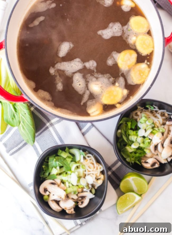 Close-up shot of chicken broth simmering gently in a pot, infused with aromatic ginger, garlic, and savory sauces, creating the rich base for the hot pot.