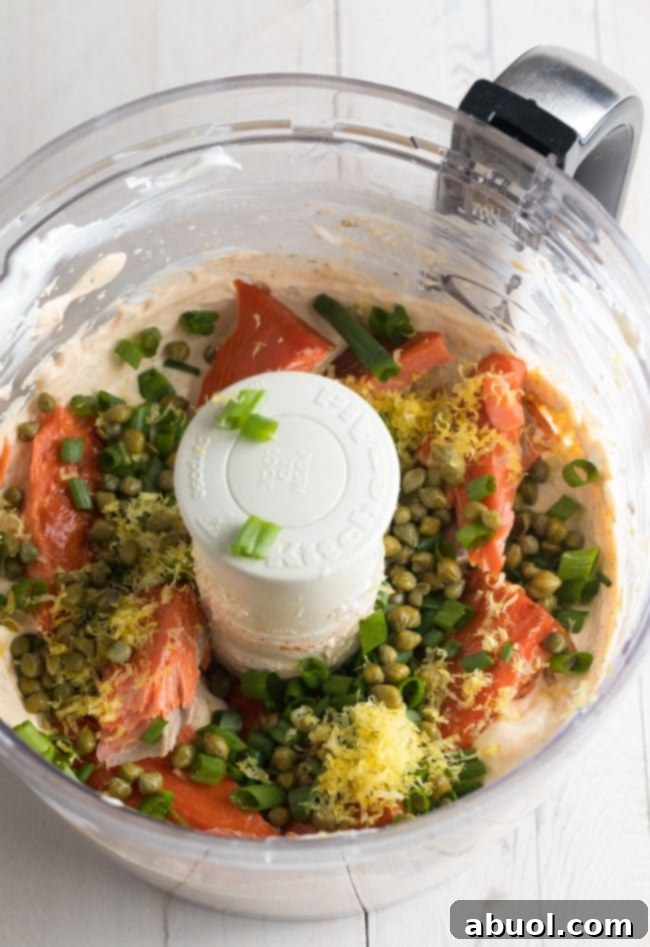 Creamy Smoked Salmon Dip 5 The second half of the ingredients for the dip, including smoked salmon, green onions, and capers, added to the food processor for final blending.