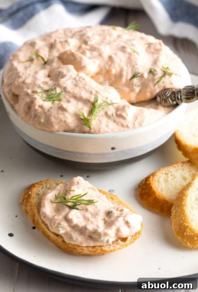 Creamy Smoked Salmon Dip 7 Little metal spreader with some creamy smoked salmon dip on a piece of toasted bread, ready to be enjoyed.