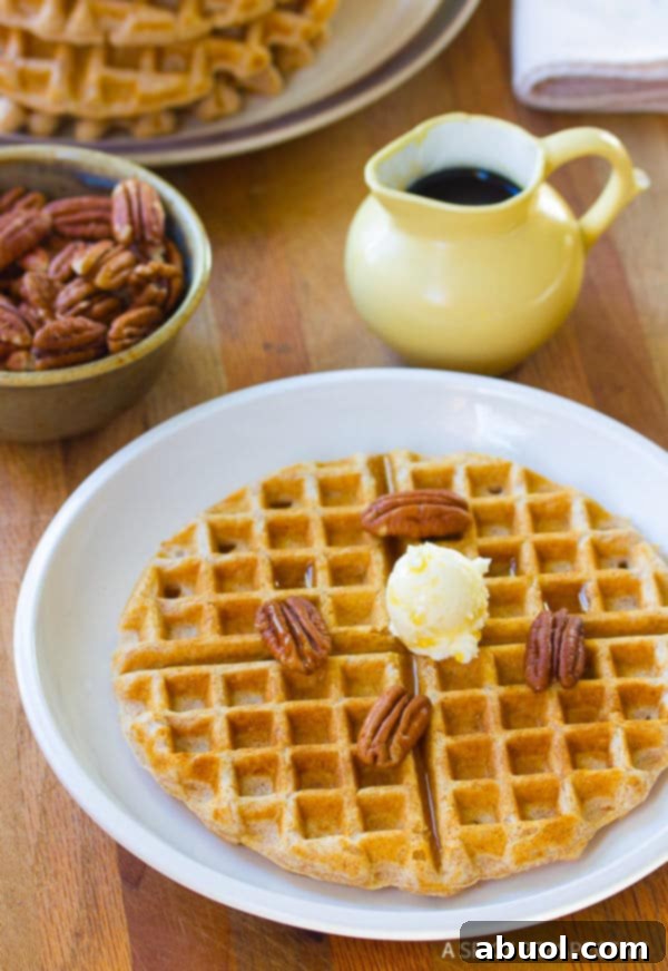A stack of perfectly golden-brown crispy spelt waffles, ready for toppings.