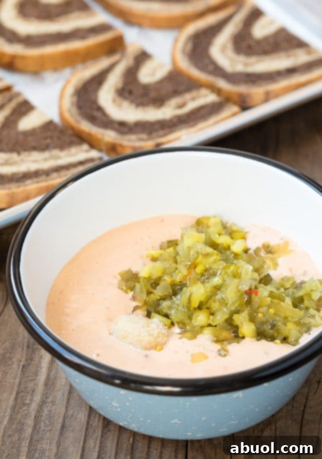 Thousand island dressing in a bowl mixed with horseradish and relish. A creamy, pinkish dressing.