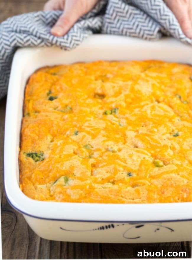 Close-up of fluffy broccoli cornbread, showing the vibrant green broccoli florets and melted cheese baked into the golden crumb, ready to be enjoyed.