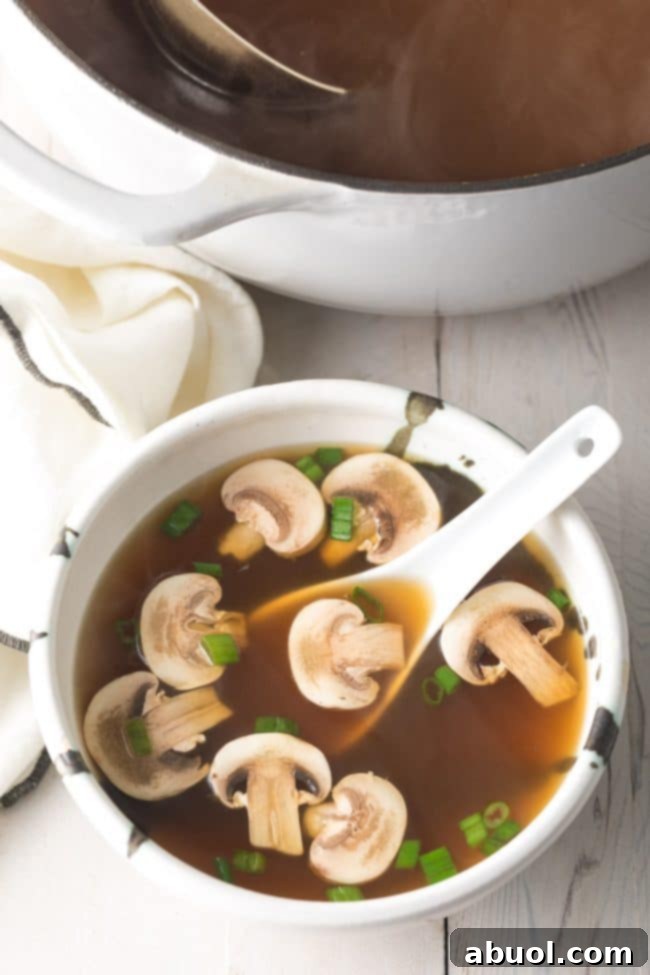 Best Japanese clear soup in a bowl with a white soup spoon.