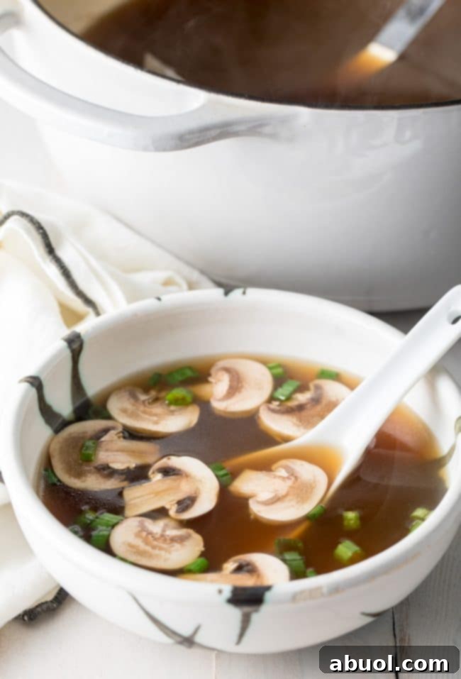 Japanese clear soup in a bowl with a large soup spoon.
