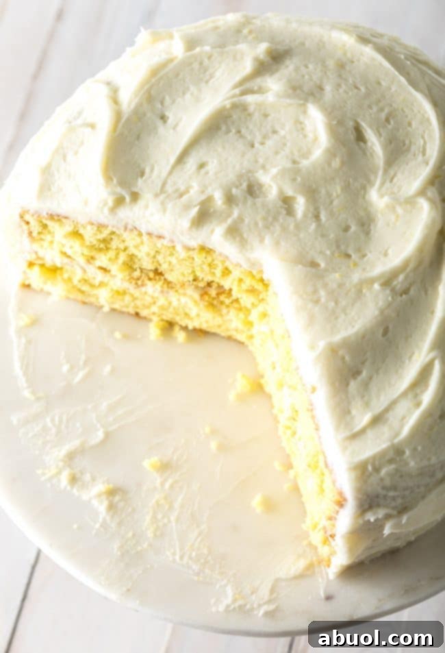 Lemon Buttermilk Cake on a cake stand with a slice taken out of the cake.