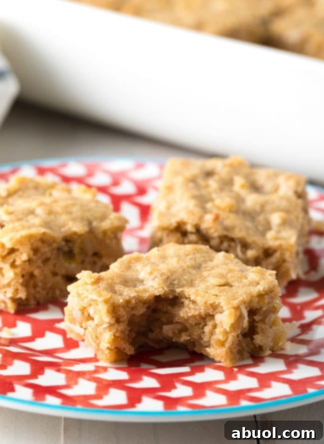 Pina Colada Blondies 4 Three blondies on a plate with one blondie missing a bite.