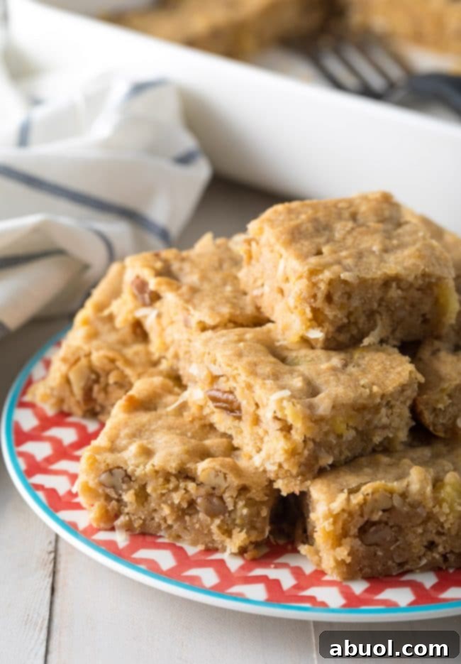 Pina Colada Blondies 8 Hummingbird cookie bars stacked on top of each other on a plate.