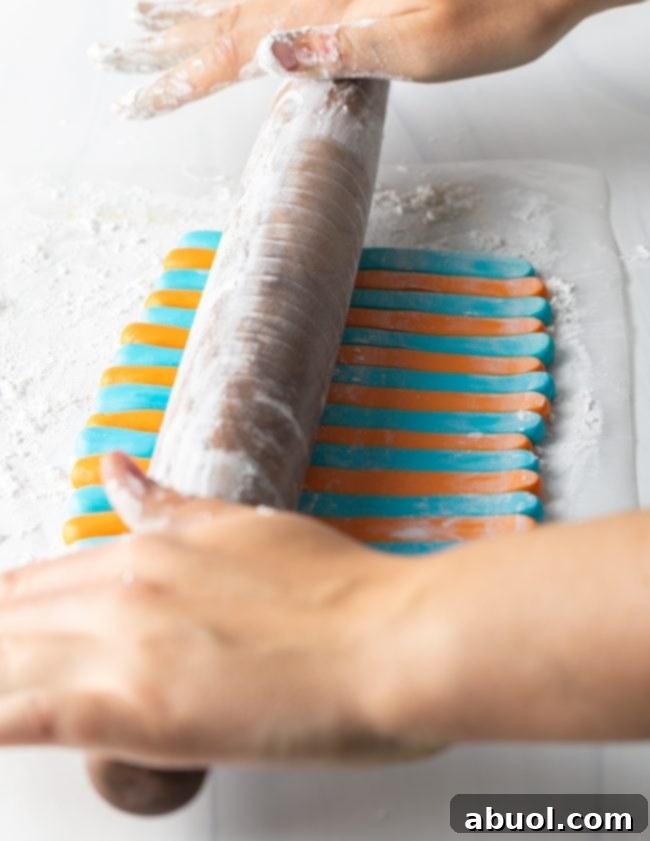 Homemade Fondant Magic 10 A hand rolling out a smooth sheet of homemade fondant on a cornstarch-dusted surface.