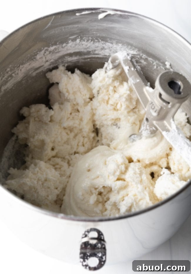 Homemade Fondant Magic 6 Marshmallow and water mixture being stirred in a microwave-safe bowl after melting, showing its smooth, gooey consistency.