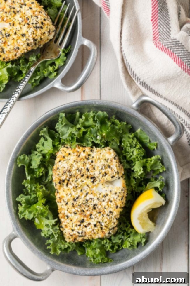 Crispy everything bagel seasoned cod presented beautifully in a bowl, garnished with fresh lettuce and a slice of lemon.