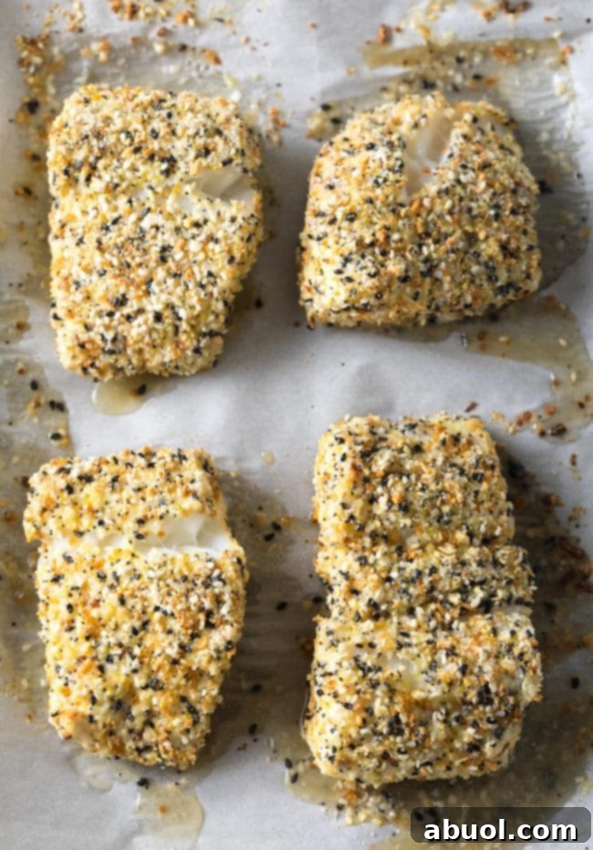 Perfectly baked white fish fillets with a crispy everything bagel crust, arranged on a baking sheet, golden and ready to serve.