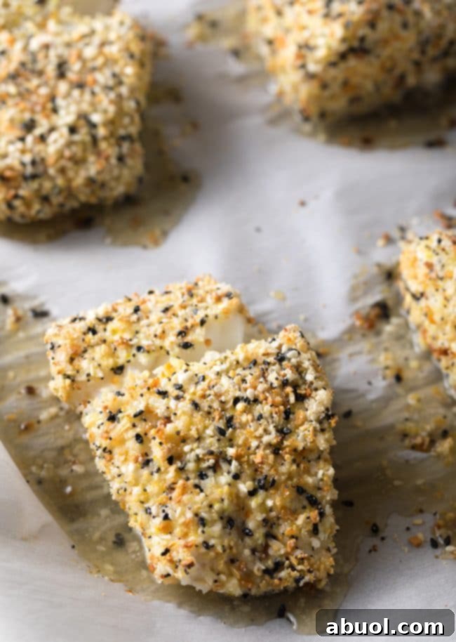 Everything bagel seasoned cod fillets freshly baked on a baking sheet, glowing golden brown and ready to be served.