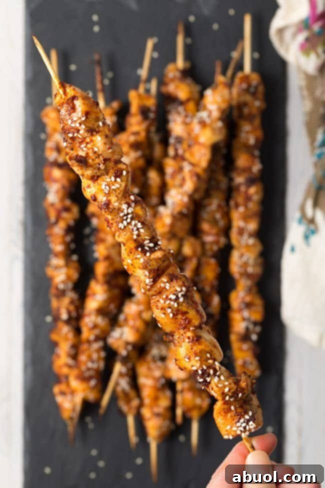 Another view of a plate of Korean chicken skewers, showcasing their vibrant color.