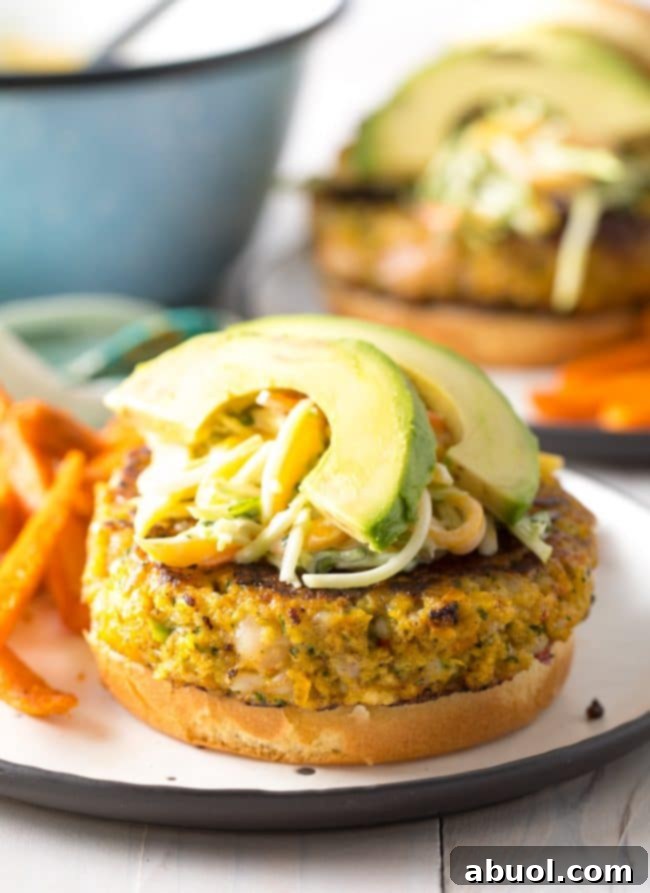 Gourmet Shrimp Burgers 3 Close-up view of a Caribbean Shrimp Burger, loaded with fresh mango slaw and vibrant toppings, showcasing its delicious texture and appeal.