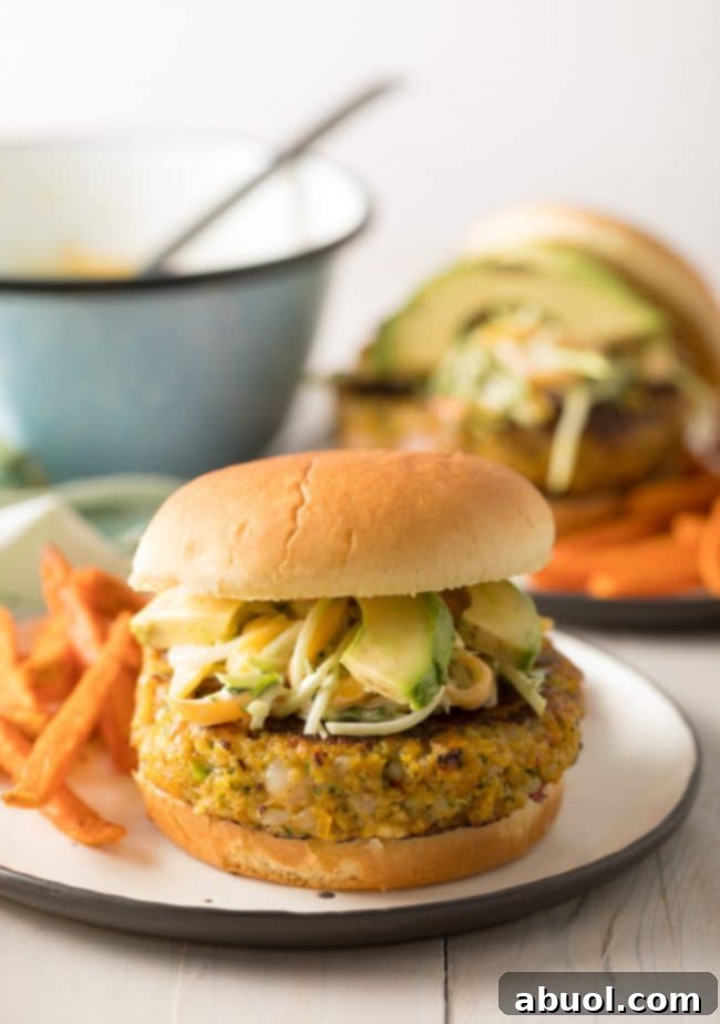 Gourmet Shrimp Burgers 5 Shrimp Burgers topped generously with homemade, vibrant mango slaw, showcasing the colorful and fresh ingredients.